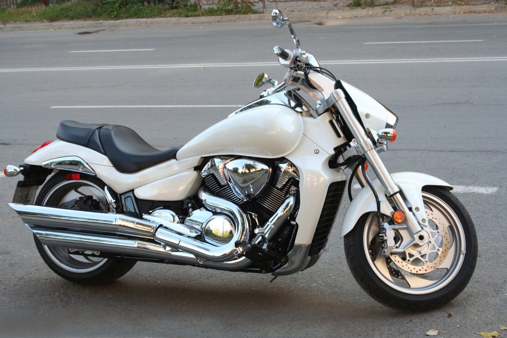 A white motorcycle parked on the side of a road.