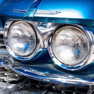 A close up of the headlights on a blue car