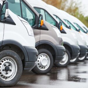 A line of white vans parked in a row.