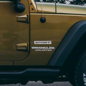 A yellow jeep parked on the side of a road.