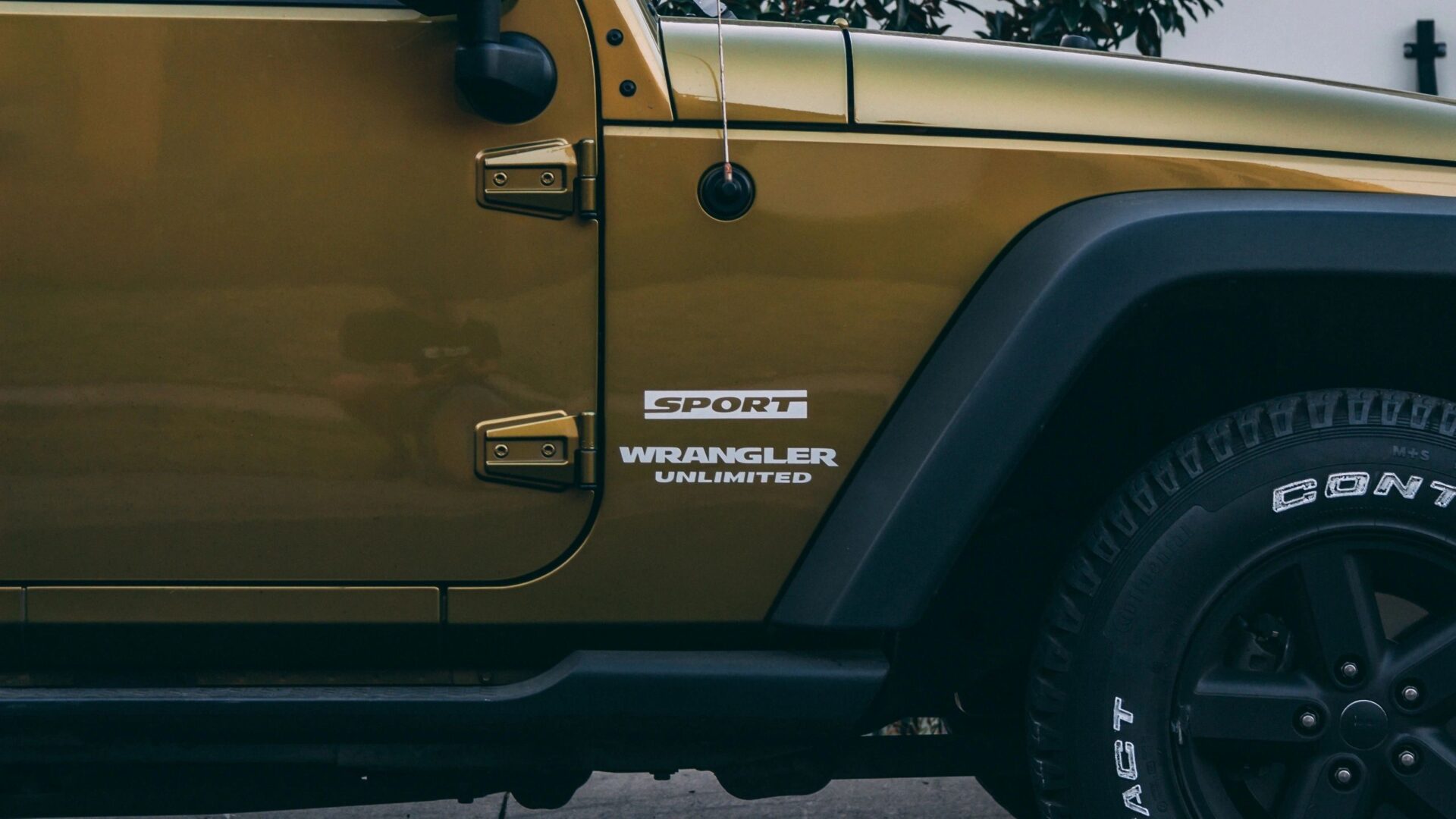 A yellow jeep parked on the side of a road.